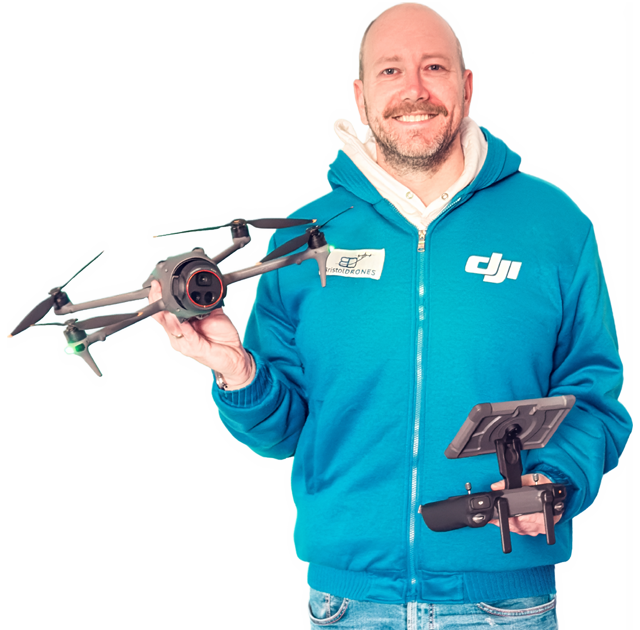 Portrait of Philippe Francken wearing a Bath Drones branded fleece holding a DJI Mavic 4 Pro drone and the DJI RC Pro 2 controller.